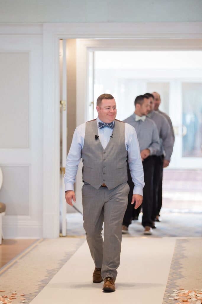 Groom and groomsman enter wedding pavilion