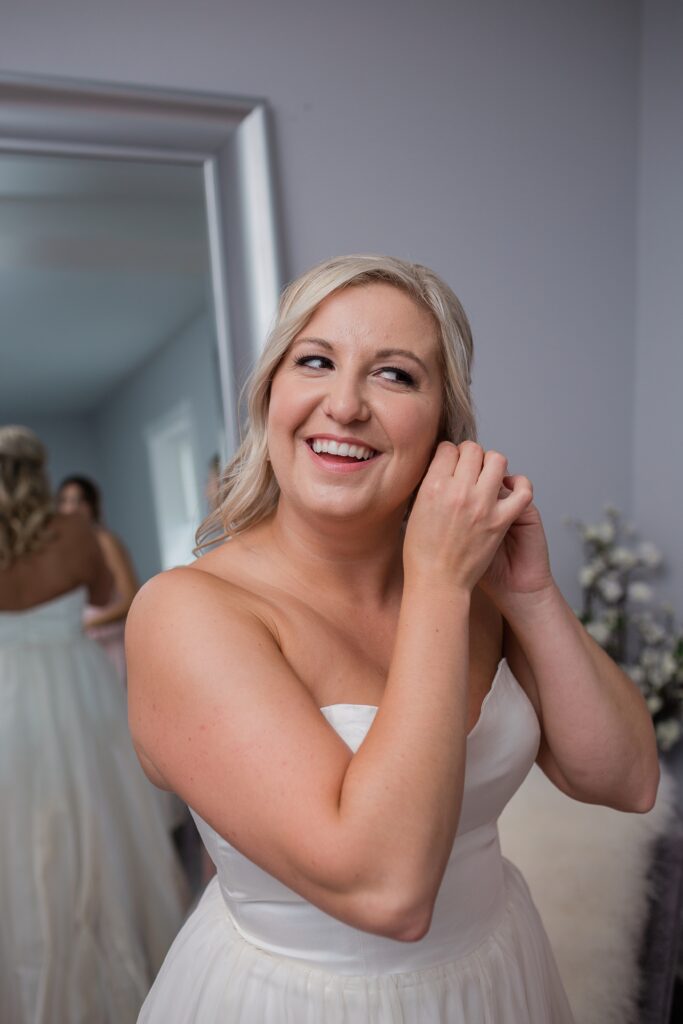 bride smiling putting in her earrings