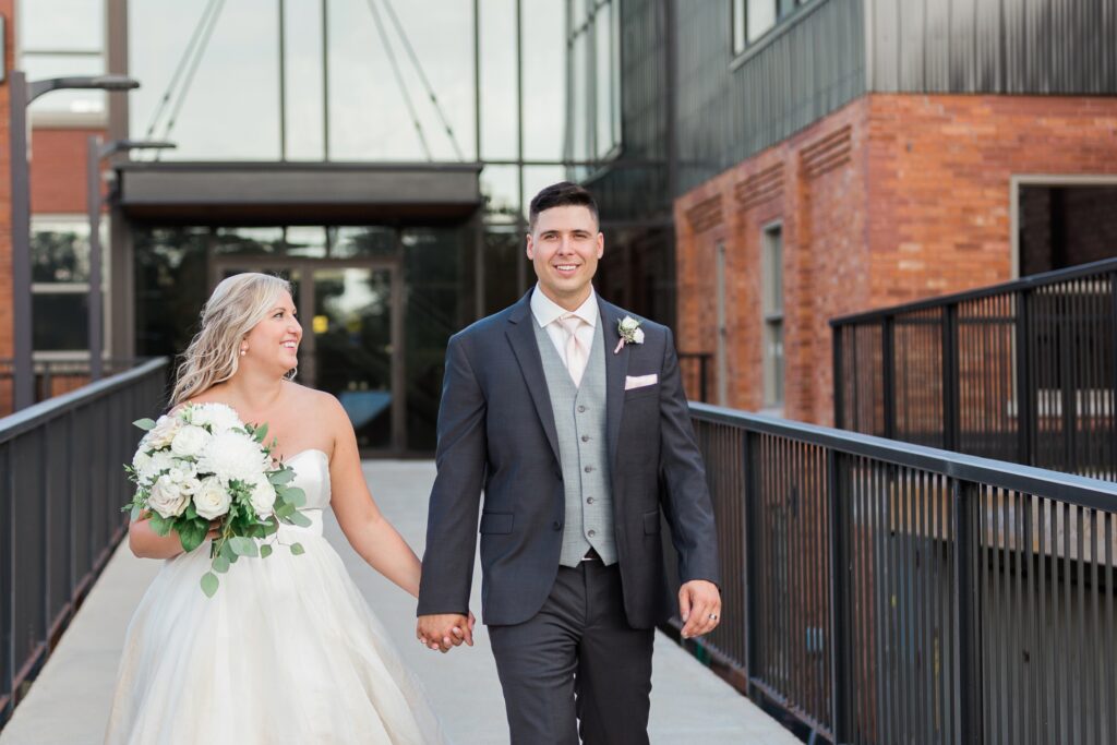 bride smiling at her groom while walking
