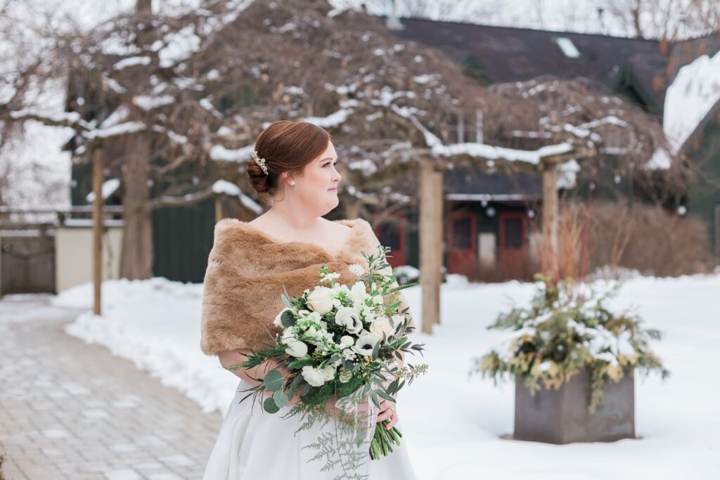 bride outside at winter wedding with faux fur scarf