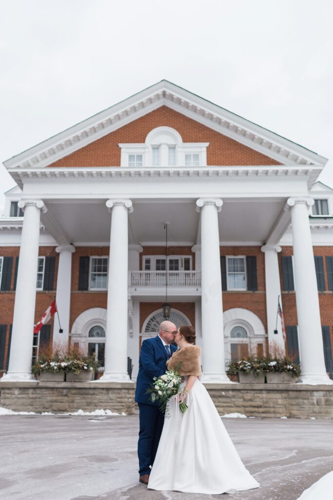 bride and groom kissing out front of Langdon Hall wedding venue