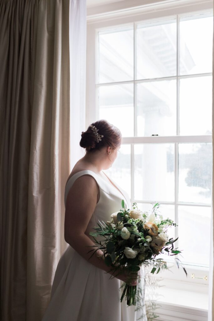 bride looking out winder in bridal suite in colour intimate