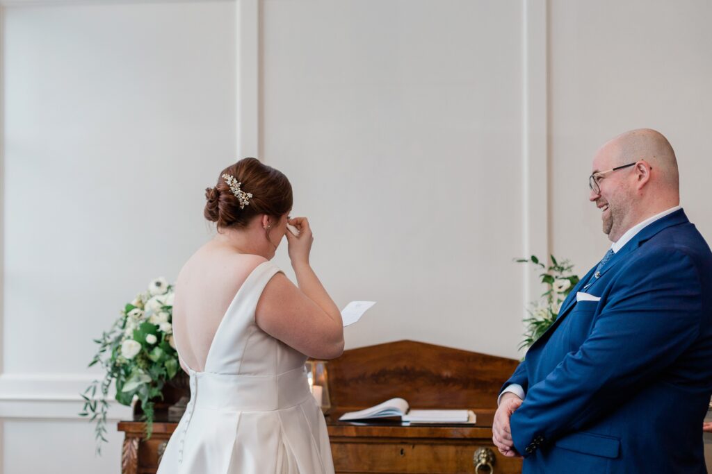 groom laughing while bride cries during ceremony