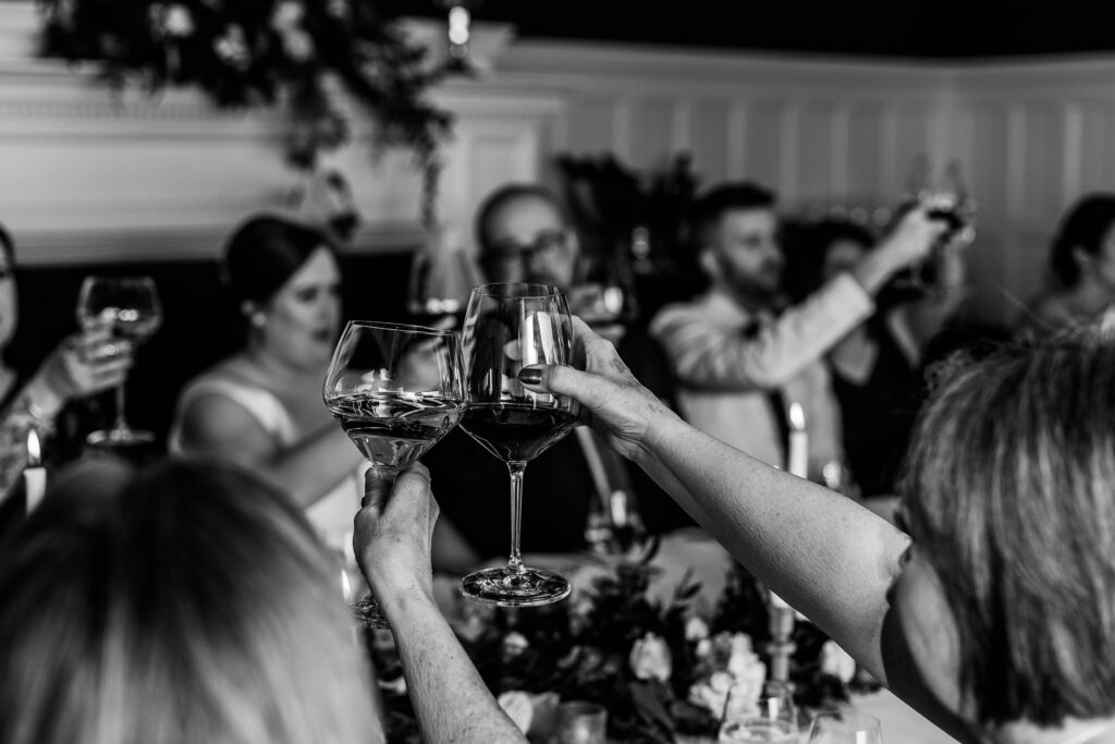 black and white photo of wine glasses toasting intimate