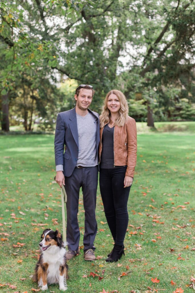 Couple standing side by side with dog