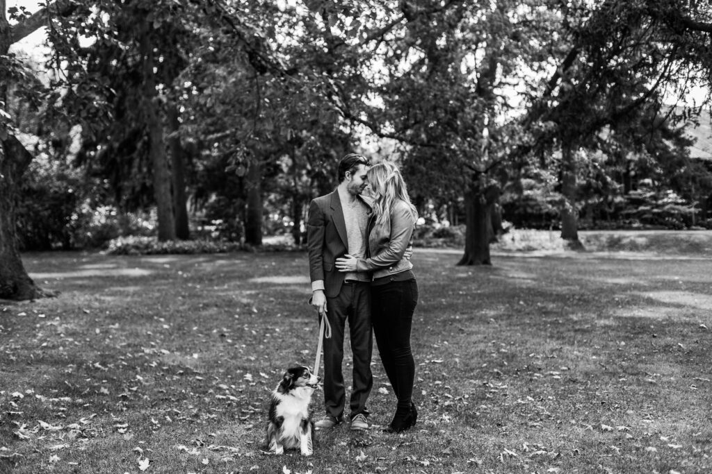 Black and white couple kissing in Victoria Park Kitchener with dog