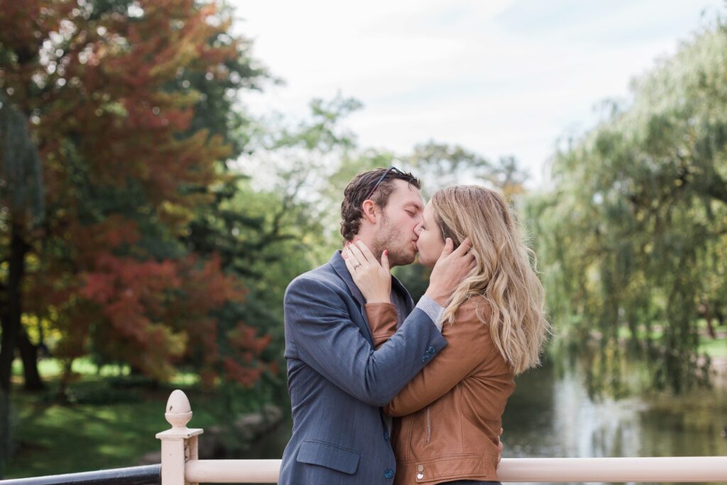 couple kissing on bridge in Victoria park Kitchener engagement session