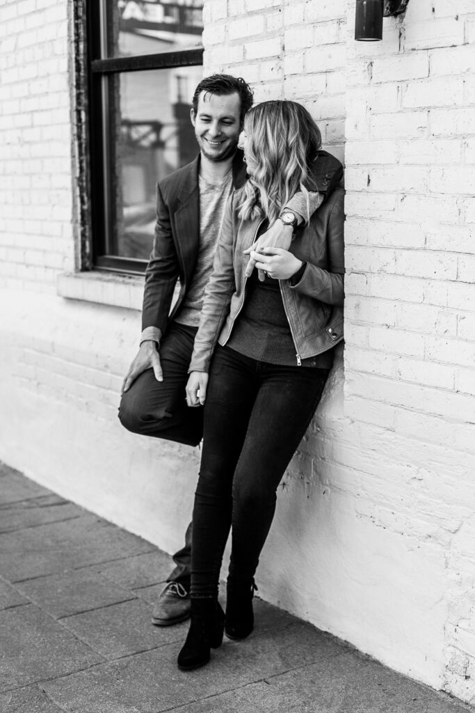 black and white photo of couple download Kitchener leaning again brick walll