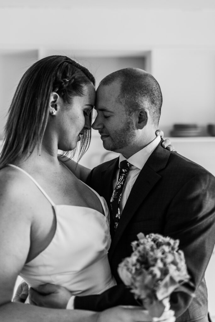 black and white image of bride and groom almost kissing close up