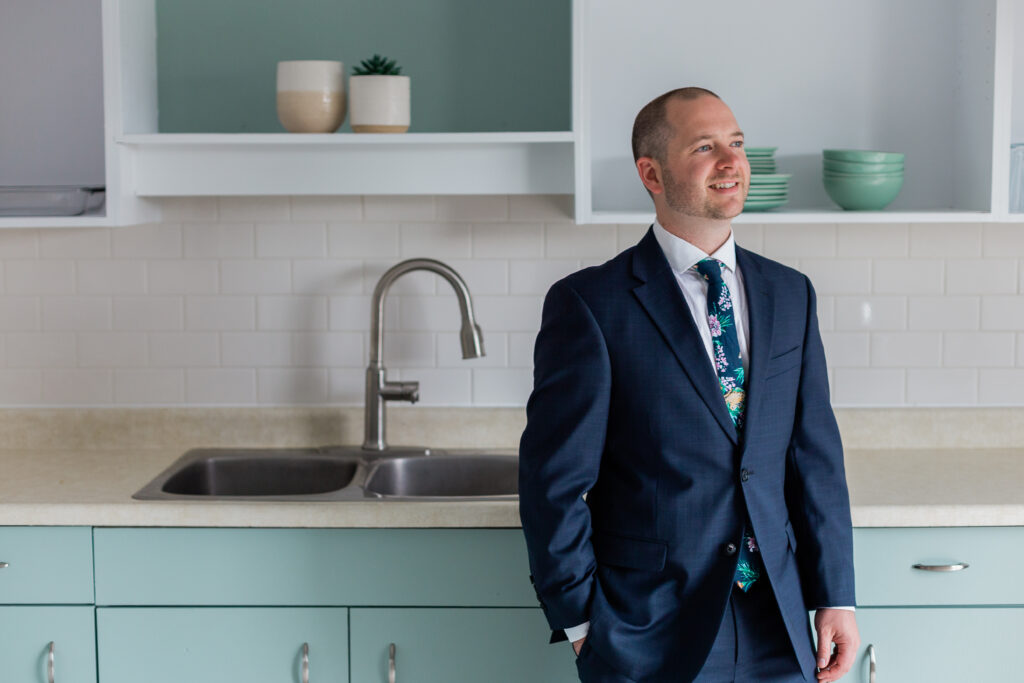 groom leaning on counter in kitchen