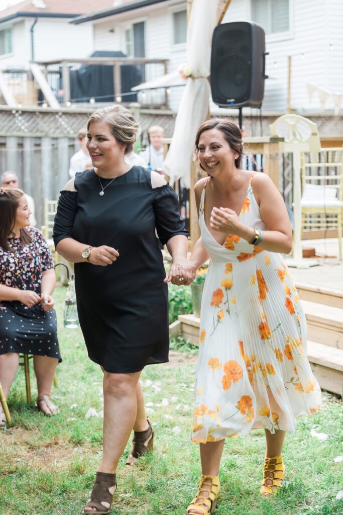 Two women arriving at a wedding while laughing