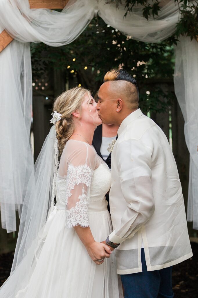 Couple kissing at a backyard wedding