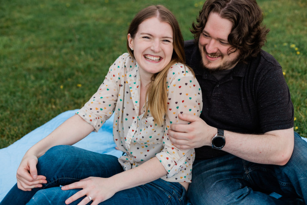 couples sitting on grass smiling at the camera