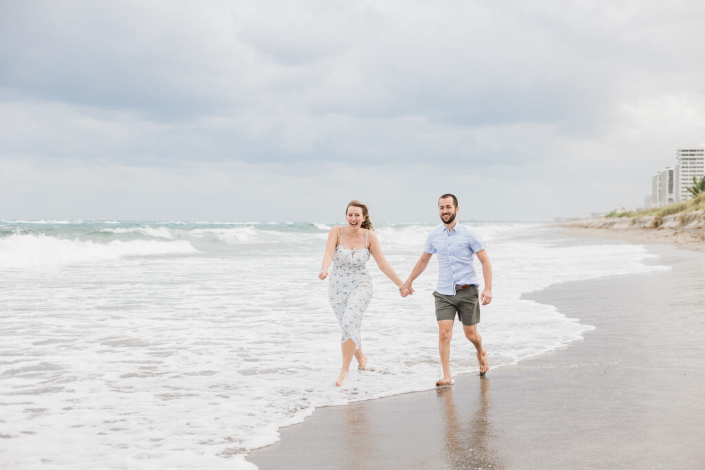 Couple running through water in Boca Raton for their engagement session