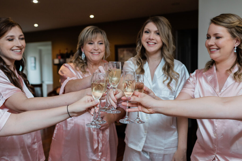 bride and bridesmaids cheering champagne in matching silk pyjamas