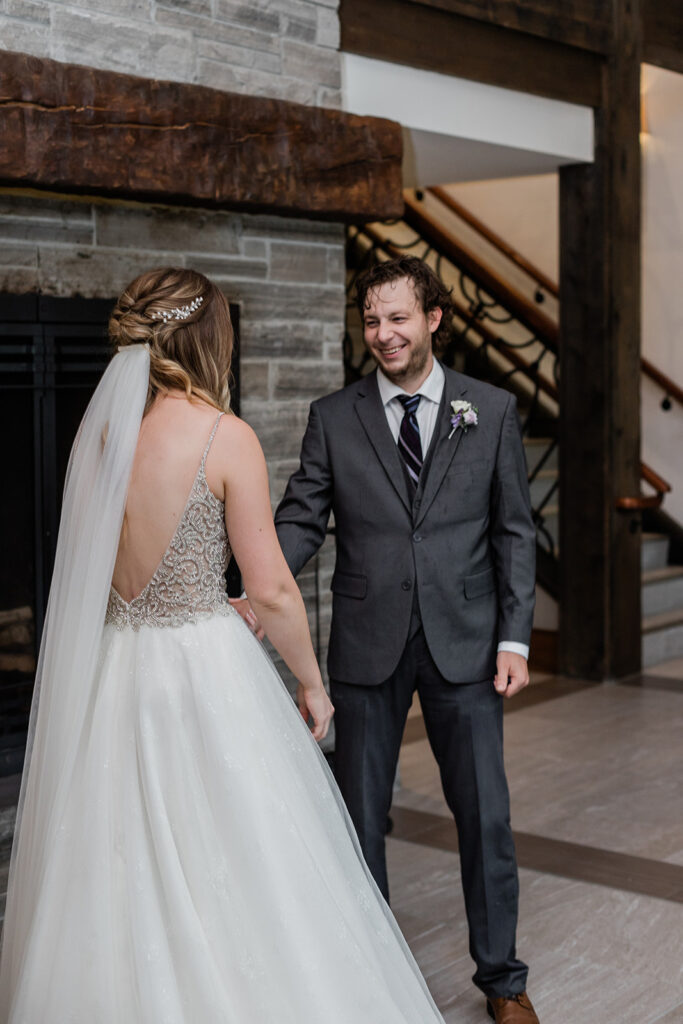 grooms smiling reaction from his first look with his bride at Whistle Bear Golf Club