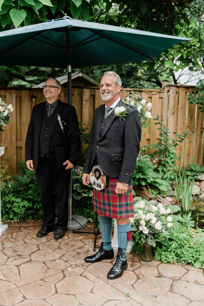 groom smiling during his backyard wedding waiting for his bride