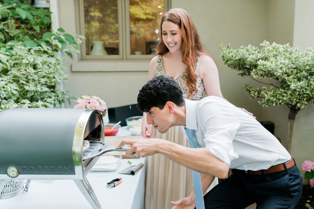 bride and groom making pizza at their elopement