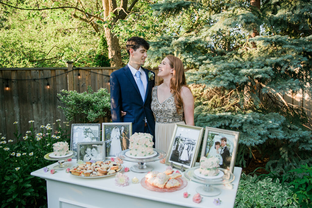 bride and groom with the dessert table at their intimate backyard elopement