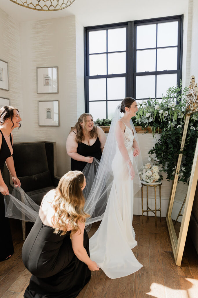 bridesmaids helping the bride put veil in before ceremony at the Elora Mill Hotel and Spa