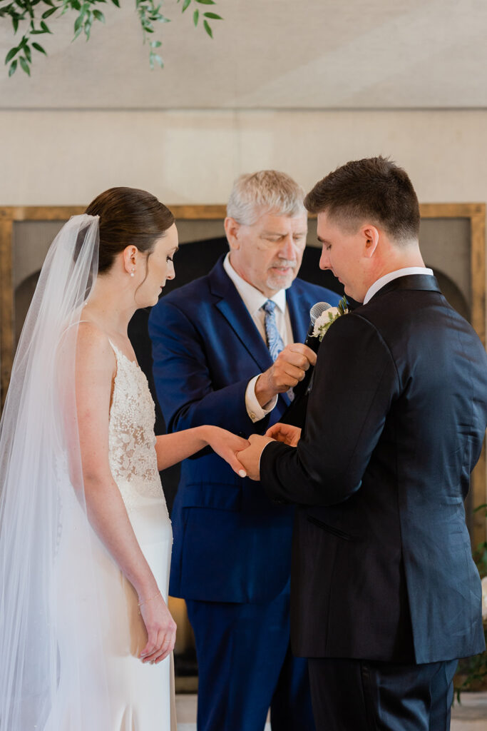 groom putting ring on his bride