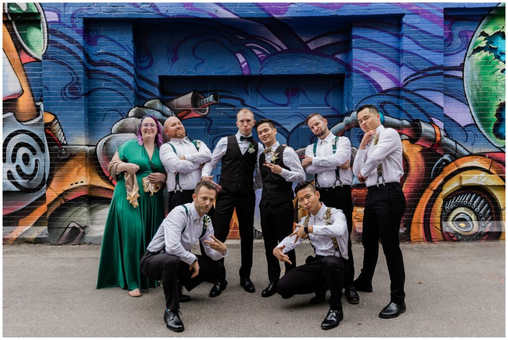 wedding party in front of wall art during downtown wedding in Kitchener, Ontario